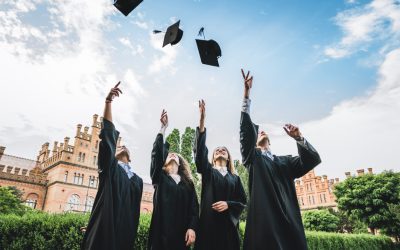 We've finally graduated!Graduates near university are throwing up hats in the air.