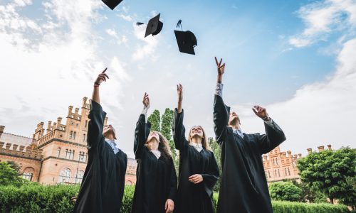 We've finally graduated!Graduates near university are throwing up hats in the air.